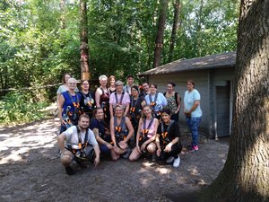 Das Team der Kita Birkhuhnweg steht gemeinsam in Kletterausrüstung im Kletterwald in Hatten.